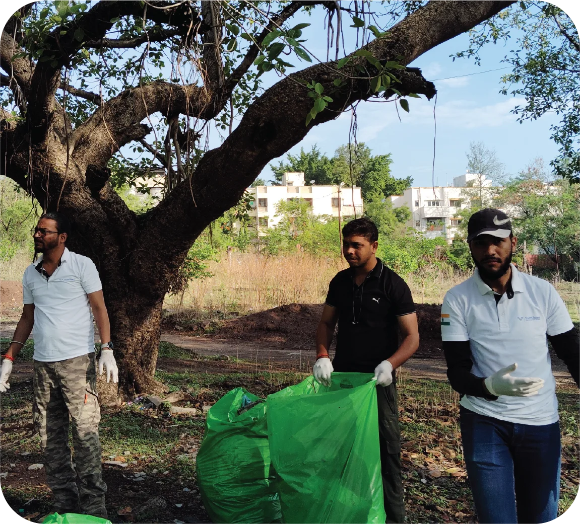 Collected waste stored in multiple green bags after a cleanup drive